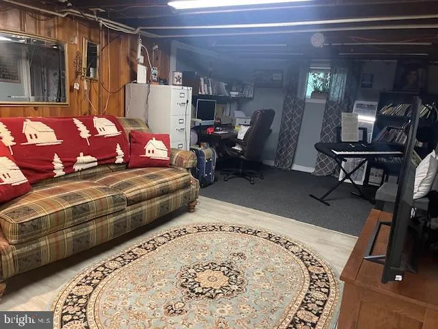a living room with furniture a flat screen tv and kitchen view