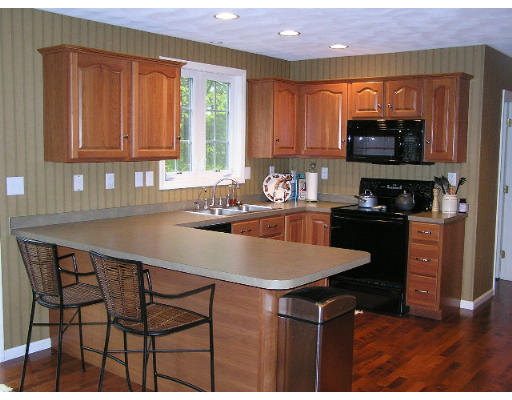 21 Simonds Farm Road Billerica, MA 01862 - Photo 4 of 16 a kitchen with stainless steel appliances a table and chairs in it