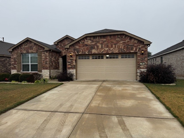 106 Calhoun Lane Georgetown, TX 78633 - Photo 1 of 16 View of front of home with a front yard, driveway, brick siding, and stone siding