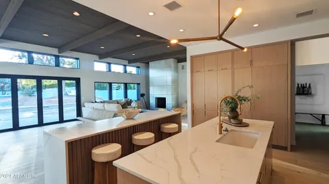 a large kitchen with kitchen island a stove a sink dishwasher and a refrigerator with wooden floor