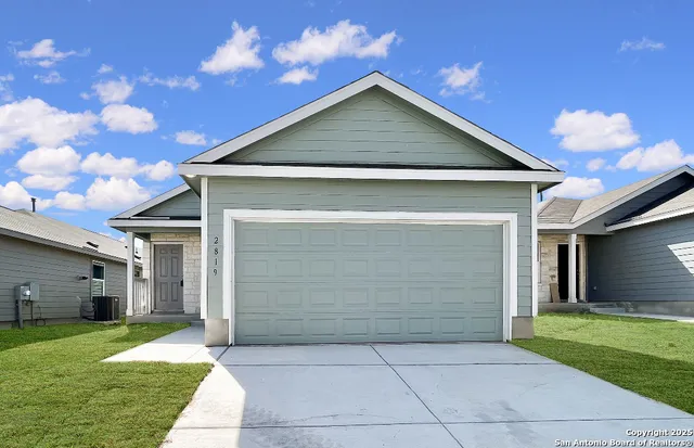 a front view of a house with a yard and garage