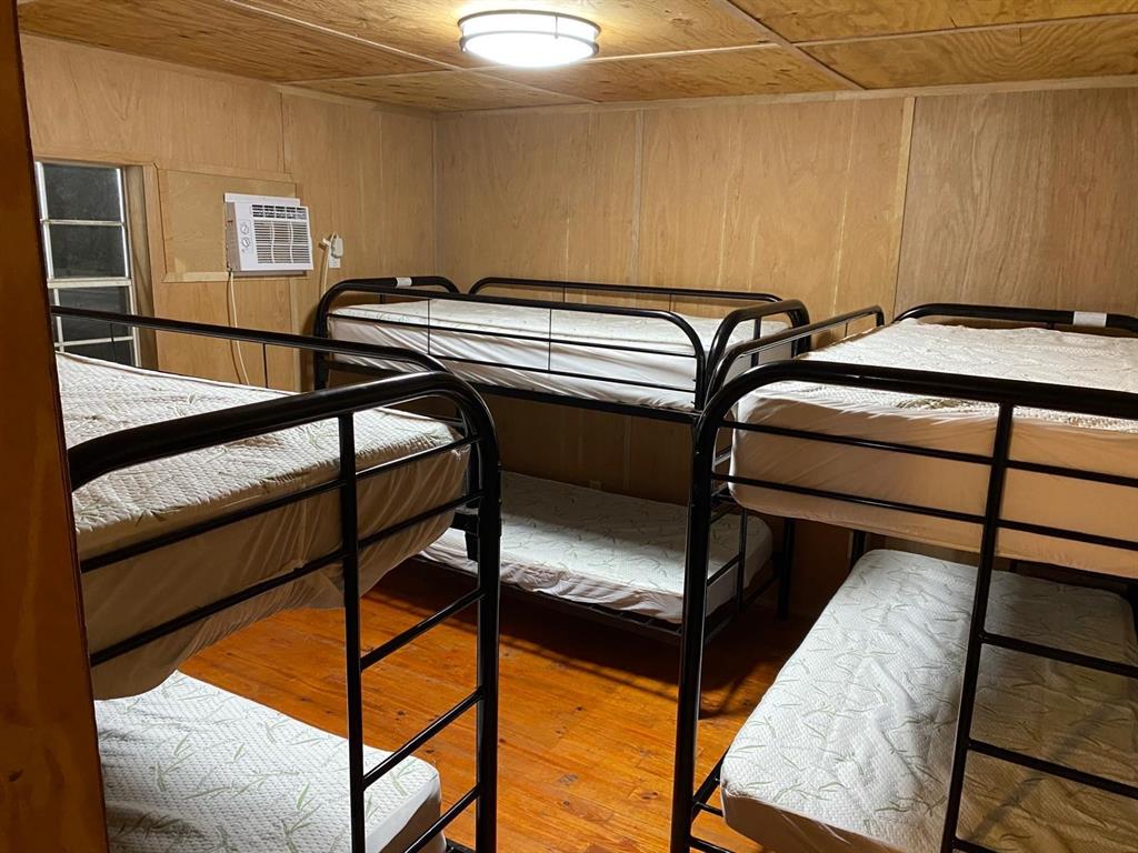160 Zigler Road Avery, TX 75554 - Photo 13 of 14 Bedroom with wood finished floors, wooden walls, a wall mounted AC, and wood ceiling