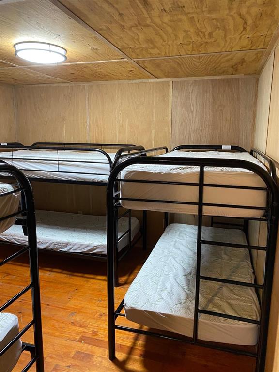 160 Zigler Road Avery, TX 75554 - Photo 14 of 14 Bedroom with wooden ceiling, wood walls, and hardwood / wood-style flooring