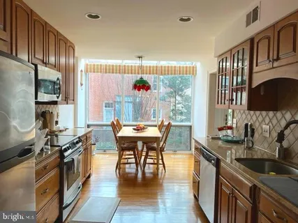 a kitchen with a table chairs stove and cabinets