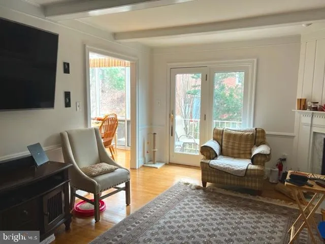 a living room with furniture a flat screen tv and a window