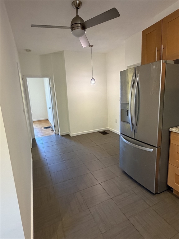 42 Fairview Street, Unit 42 Boston, MA 02131 - Photo 8 of 18 a view of a refrigerator in kitchen and an empty room with wooden floor