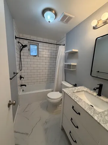 a bathroom with a granite countertop sink toilet and shower