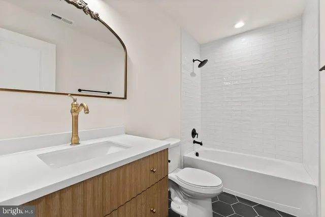 a bathroom with a sink mirror vanity and toilet