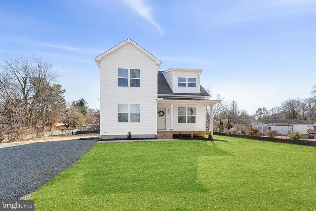 a view of house with yard and parking space