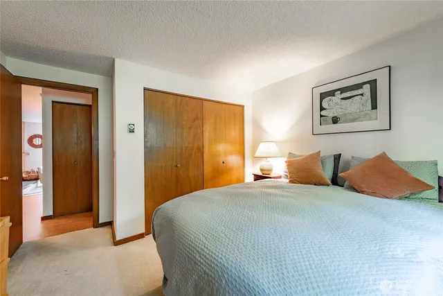 a bedroom with a bed and a painting on the wall