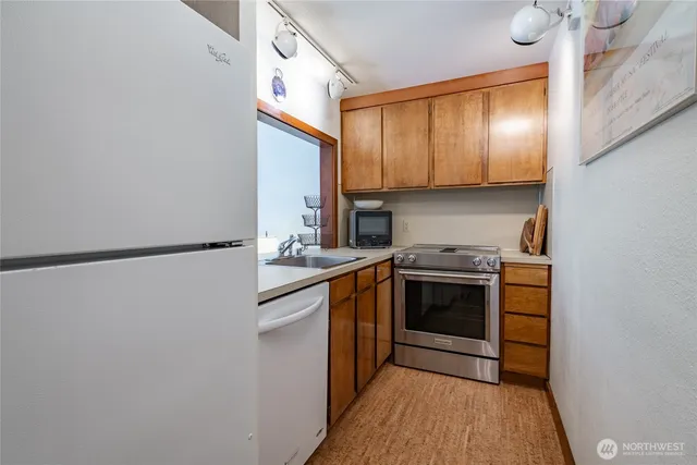 a kitchen with stainless steel appliances granite countertop a stove a sink and a refrigerator