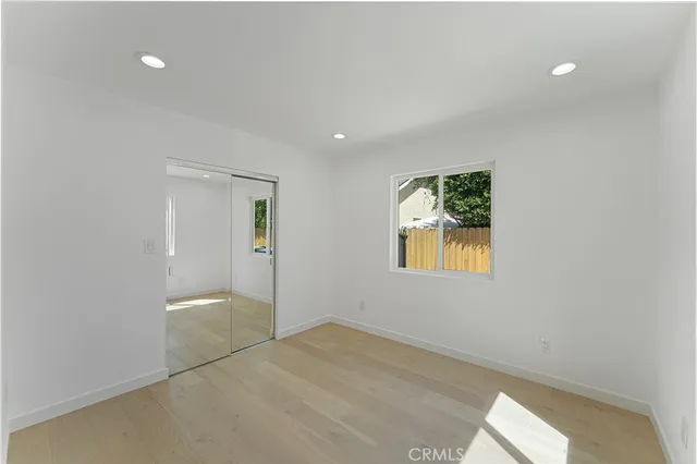 an empty room with windows and closet