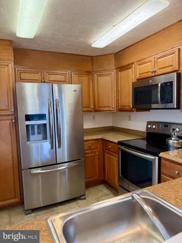 a kitchen with stainless steel appliances granite countertop a refrigerator stove and microwave