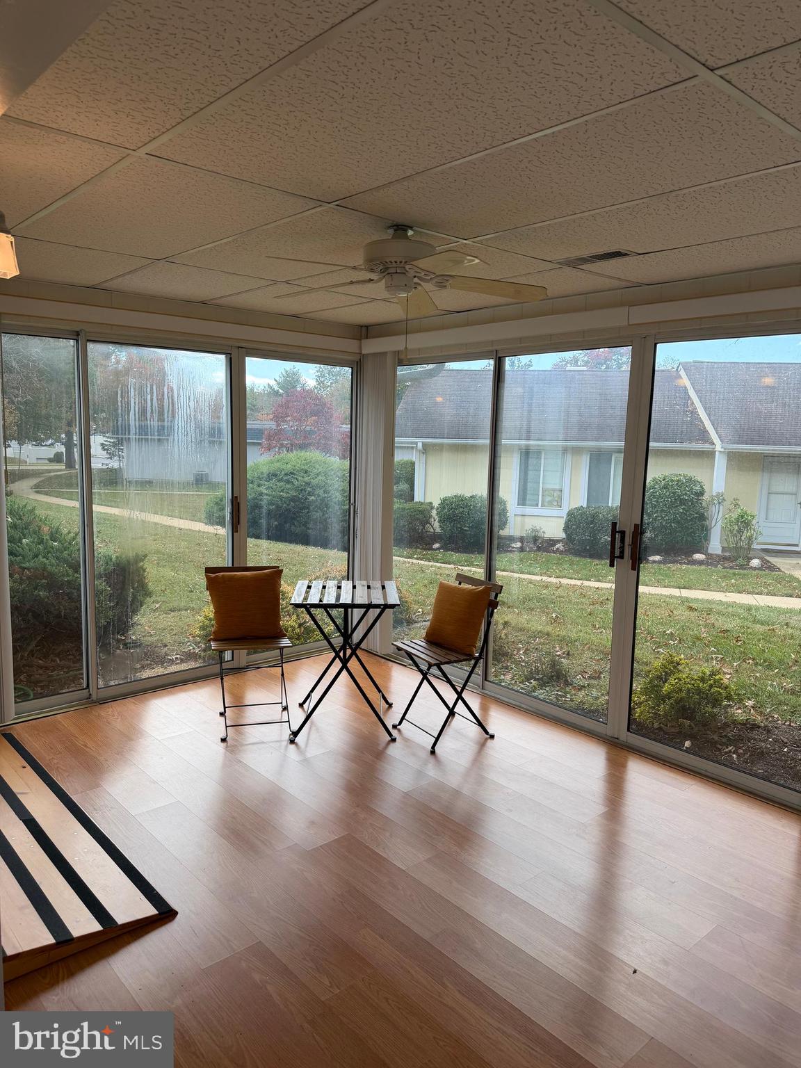 15418 Bramblewood Drive, Unit 20C Silver Spring, MD 20906 - Photo 7 of 18 a view of a patio with table and chairs floor to ceiling window with wooden floor