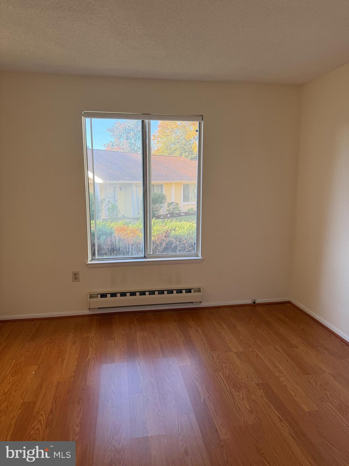 15418 Bramblewood Drive, Unit 20C Silver Spring, MD 20906 - Photo 10 of 18 an empty room with wooden floor and windows