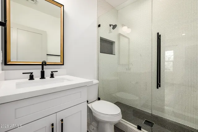 a bathroom with a sink vanity mirror and toilet