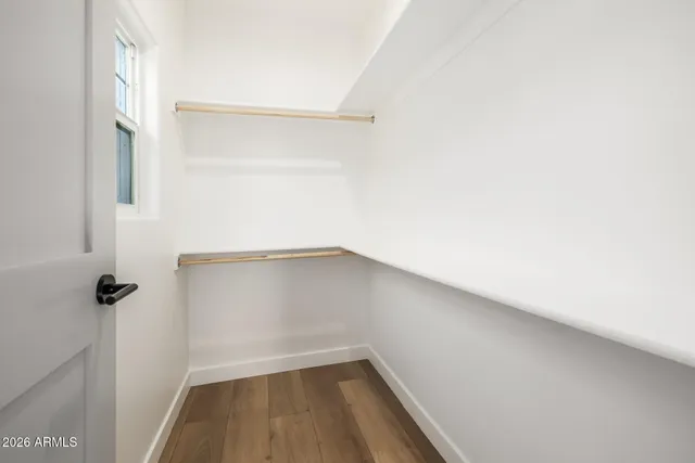 a view of a small space with wooden floor and a window