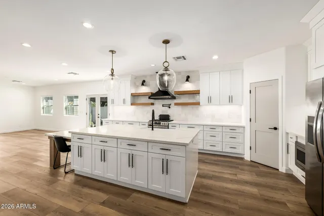 a kitchen with white cabinets and sink
