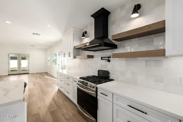 a kitchen with a stove and a wooden floor