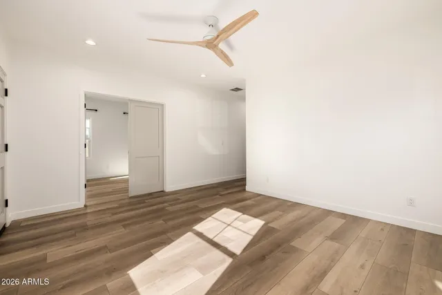 an empty room with wooden floor and windows
