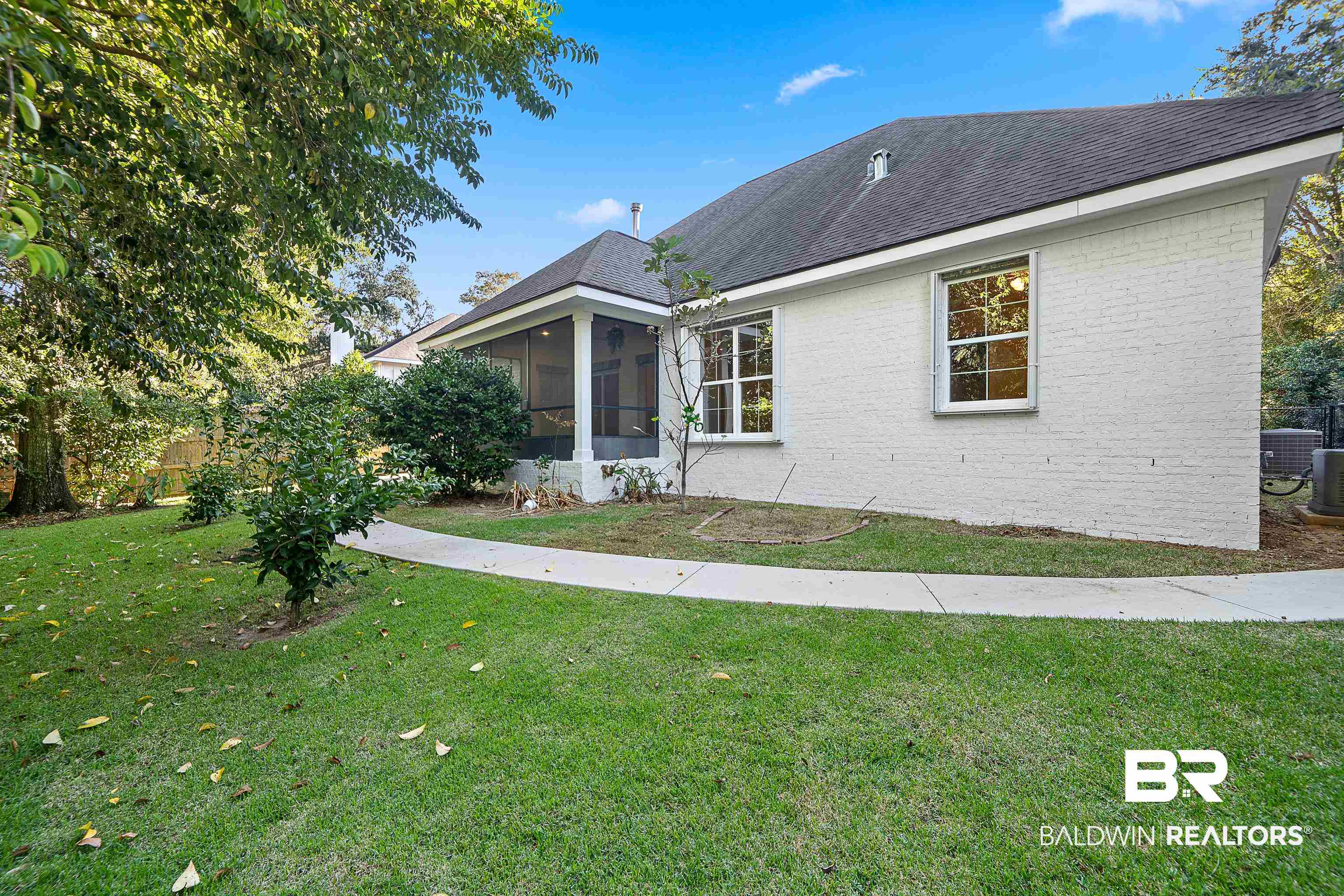 356 Liberty Street Fairhope, AL 36532 - Photo 35 of 39 View of front of home featuring a sunroom, a front yard, brick siding, and roof with shingles