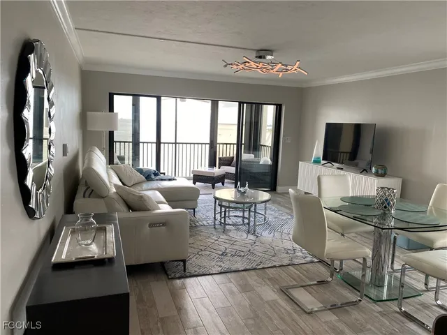 a living room with furniture a flat screen tv and a large window
