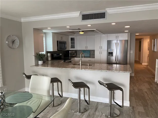 a kitchen with stainless steel appliances granite countertop a table and chairs