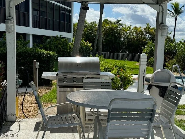 a view of a patio with table and chairs potted plants with wooden floor and fence