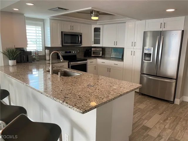 a kitchen with stainless steel appliances granite countertop a sink a stove and a refrigerator