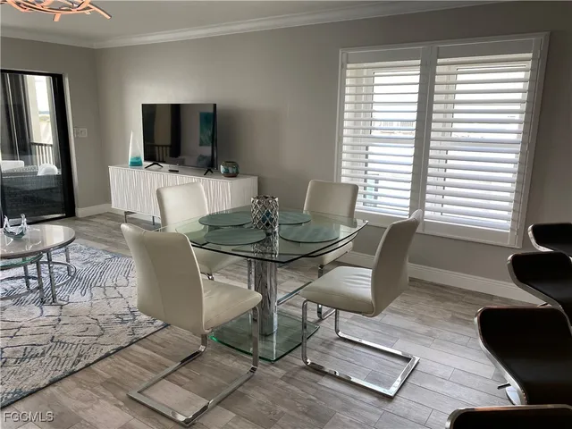 a view of a dining room with furniture a rug and wooden floor