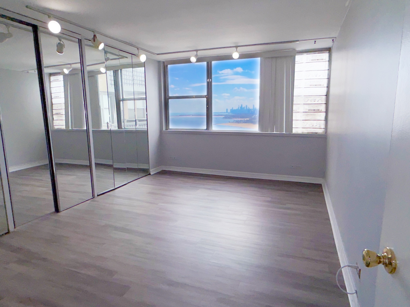 6301 North Sheridan Road, Unit 24E Chicago, IL 60660 - Photo 5 of 57 a view of an empty room with wooden floor and a window