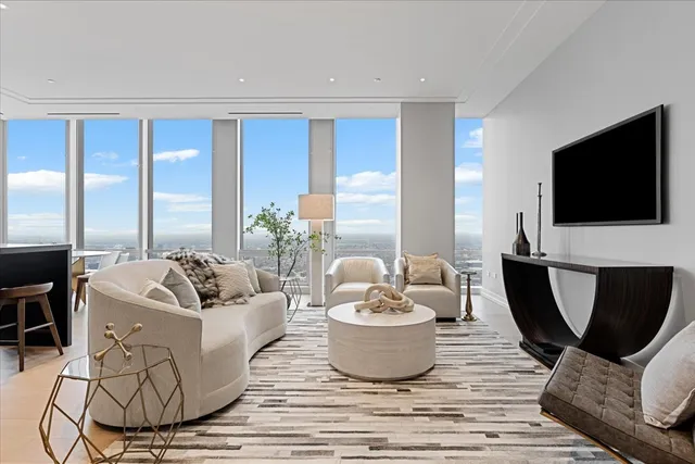 a living room with furniture a flat screen tv and a large window