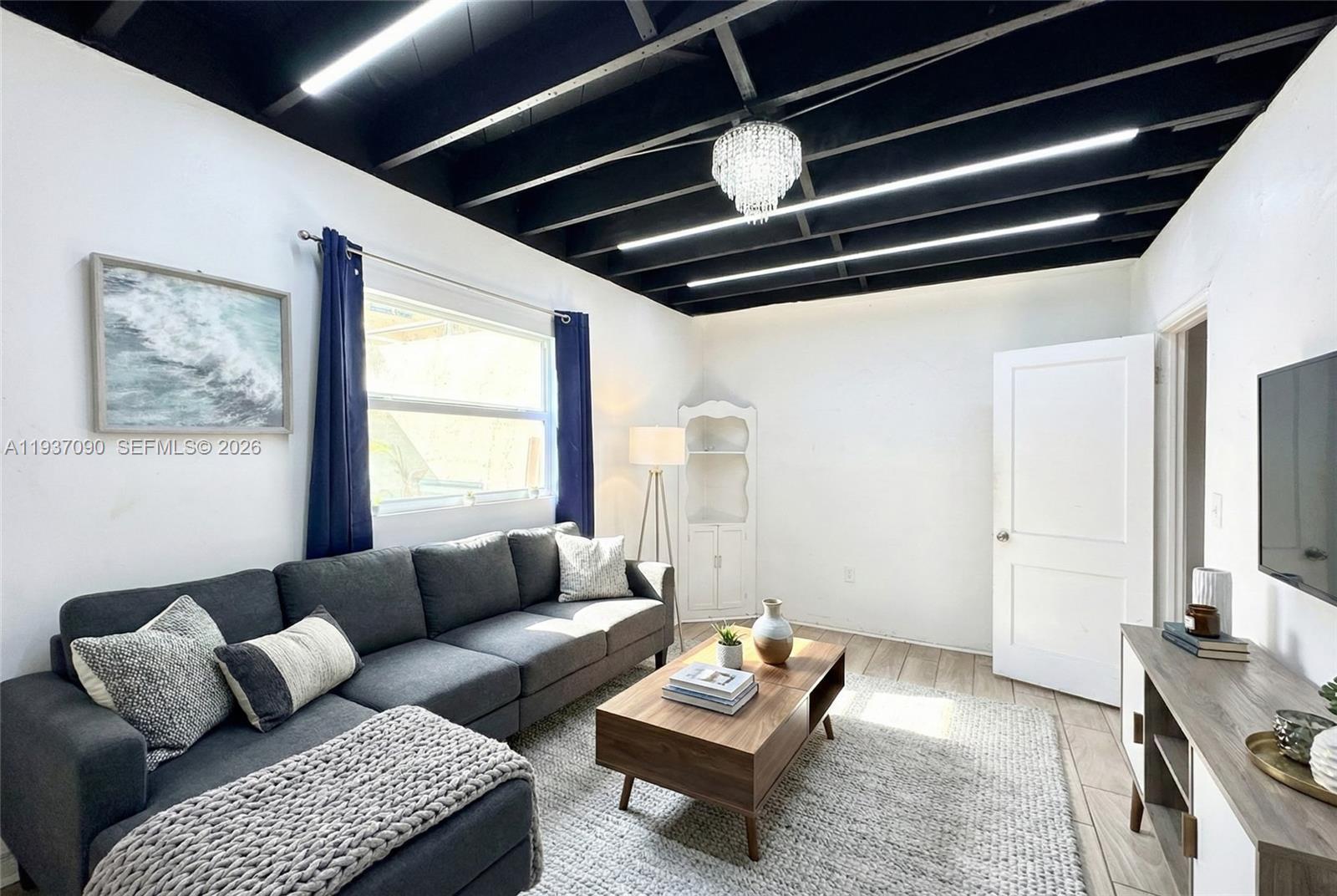 7820 Harding Avenue Miami Beach, FL 33141 - Photo 11 of 13 a living room with furniture and a window
