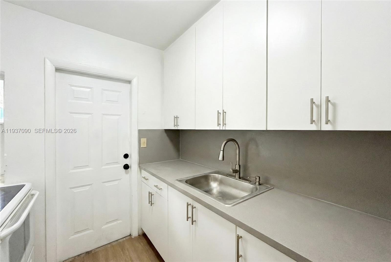 7820 Harding Avenue Miami Beach, FL 33141 - Photo 12 of 13 a kitchen with a sink and cabinets