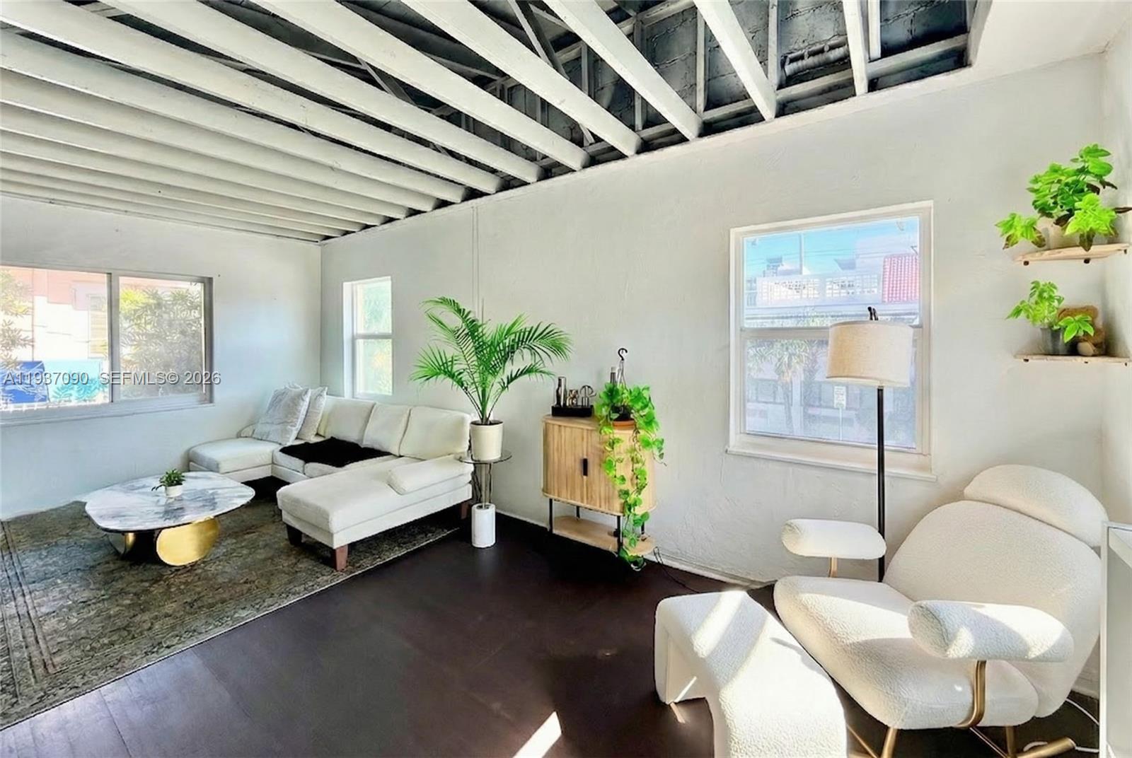 7820 Harding Avenue Miami Beach, FL 33141 - Photo 5 of 13 a living room with patio furniture and a potted plant