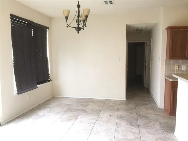 a view of a kitchen with kitchen island wooden floors and stainless steel appliances