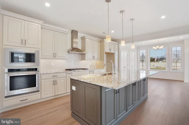 a kitchen with stainless steel appliances kitchen island a cabinets and a wooden floor