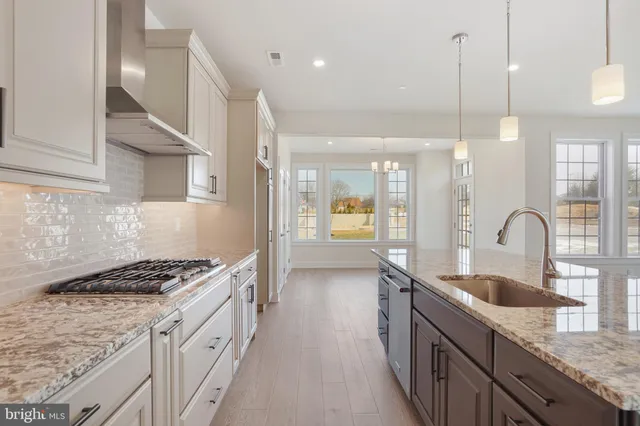 a kitchen with granite countertop a sink a counter space appliances and cabinets