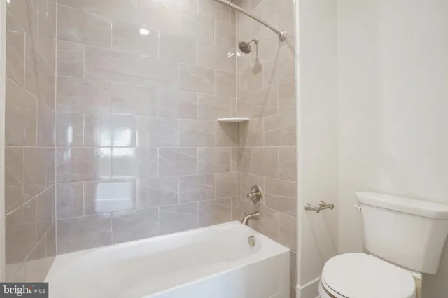 a white toilet sitting next to a bath tub and shower