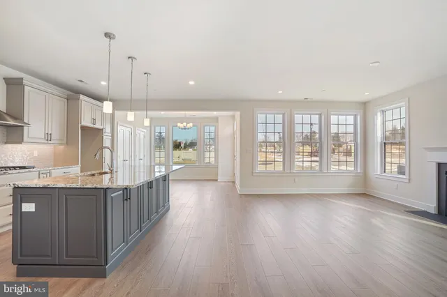 a large kitchen with kitchen island wooden floors and stainless steel appliances