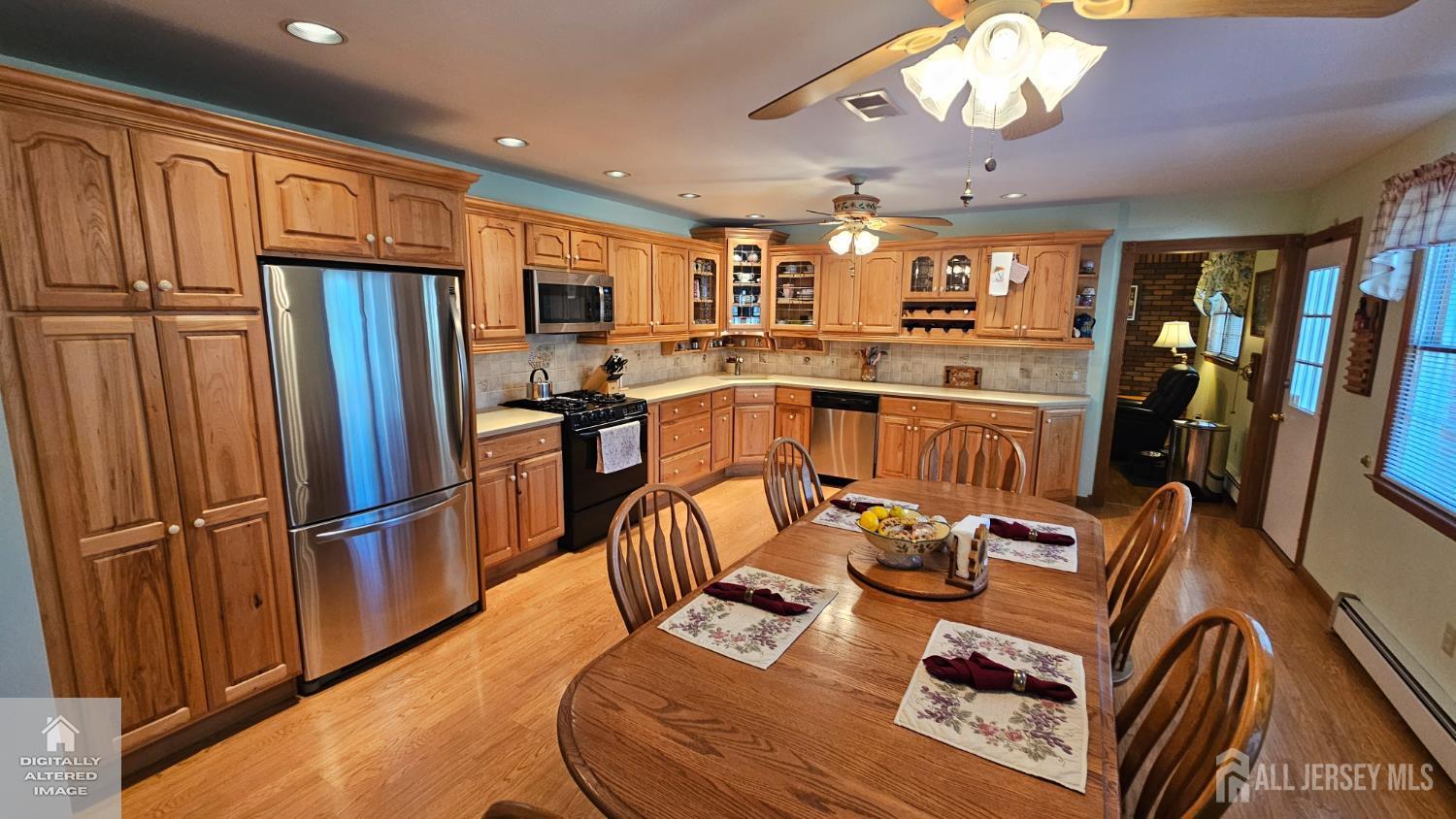 263 New Road Monmouth Junction, NJ 08852 - Photo 29 of 70 a kitchen with stainless steel appliances granite countertop a refrigerator a stove top oven a dining table and chairs with wooden floor