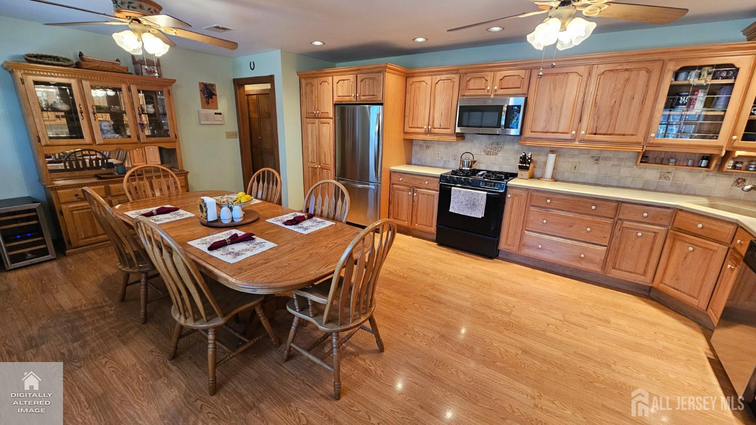 263 New Road Monmouth Junction, NJ 08852 - Photo 31 of 70 a kitchen with stainless steel appliances granite countertop a stove a refrigerator a kitchen island a dining table and chairs with wooden floor
