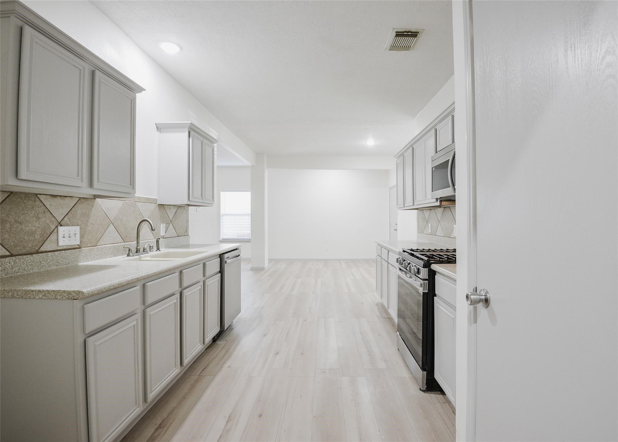 6627 Stonecross Creek Lane Katy, TX 77449 - Photo 13 of 30 a kitchen with granite countertop a sink stove and refrigerator