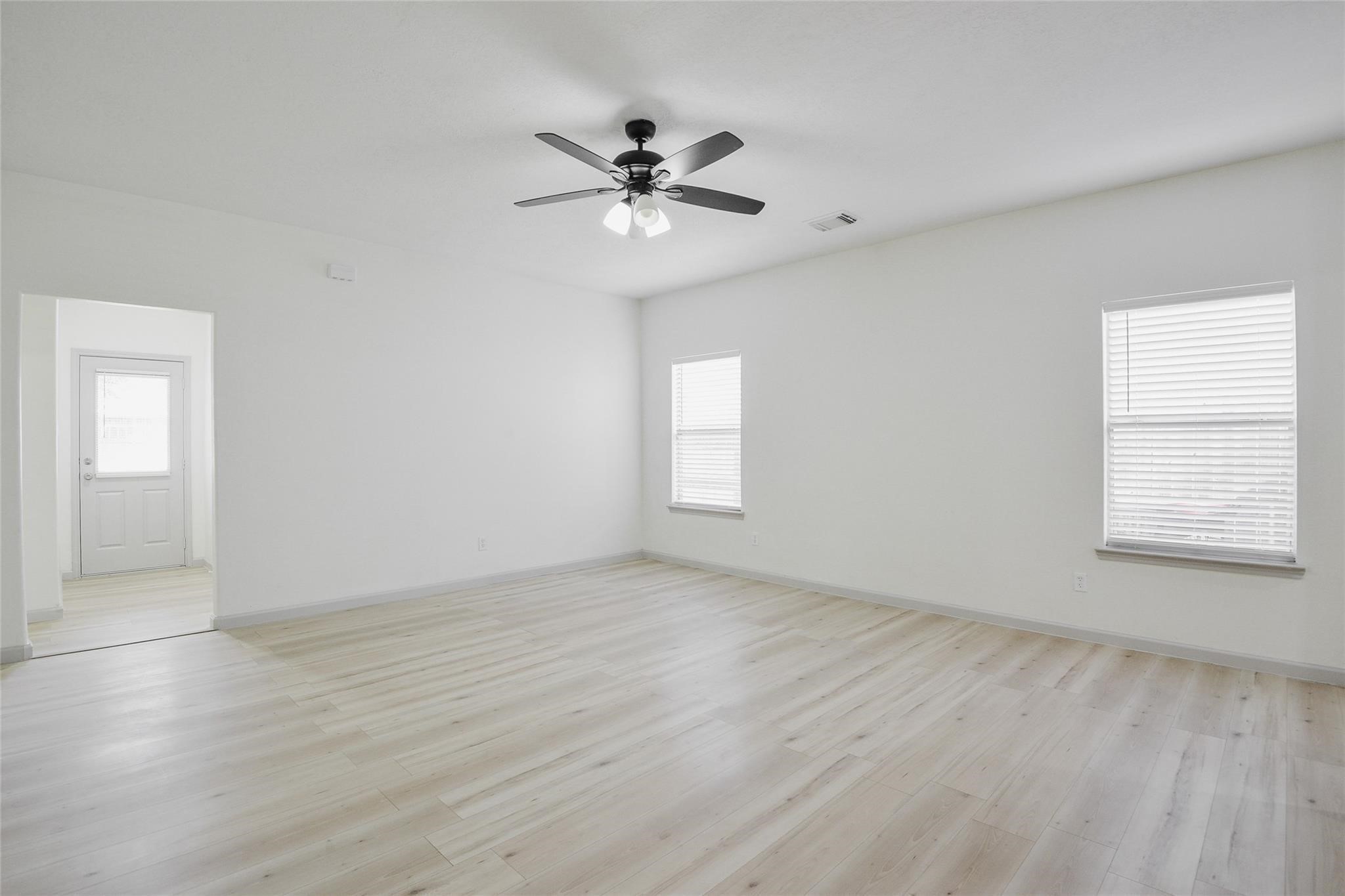 6627 Stonecross Creek Lane Katy, TX 77449 - Photo 15 of 30 an empty room with wooden floor fan and windows