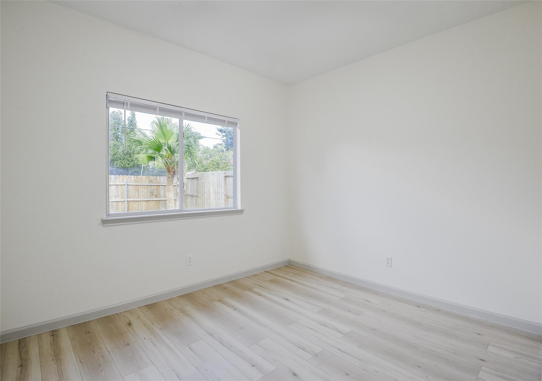 6627 Stonecross Creek Lane Katy, TX 77449 - Photo 24 of 30 an empty room with wooden floor and windows
