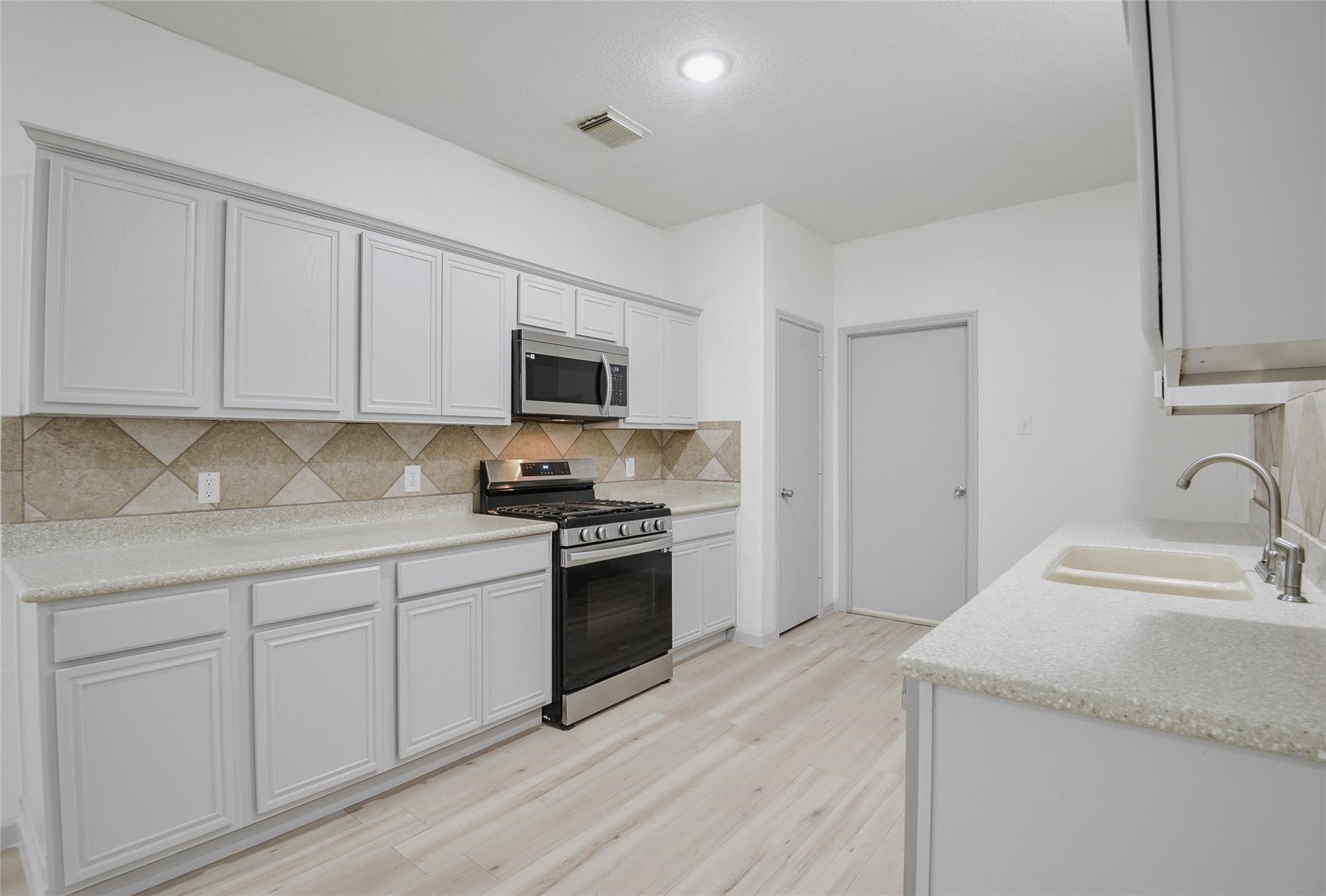 6627 Stonecross Creek Lane Katy, TX 77449 - Photo 8 of 30 a kitchen with granite countertop a sink and a stove top oven