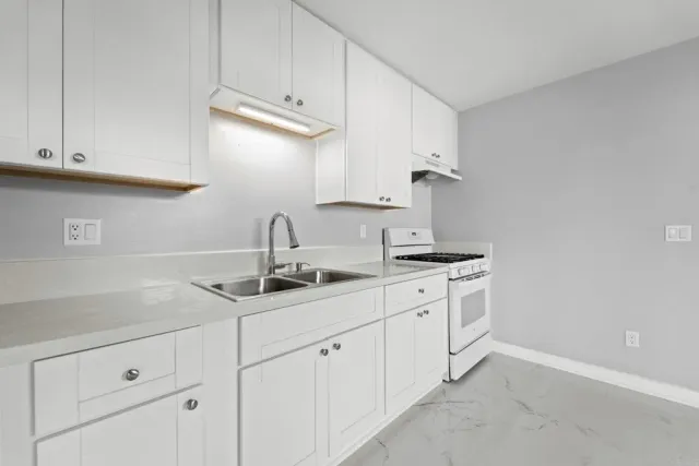a kitchen with white cabinets and a sink