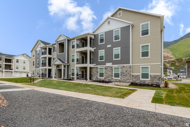 4662 Poplar Way, Unit Q201 Mapleton, UT 84664 - Photo 1 of 5 Contemporary multi-story building featuring stacked stone veneer, horizontal siding, private balconies with dark railings, and a covered main entrance