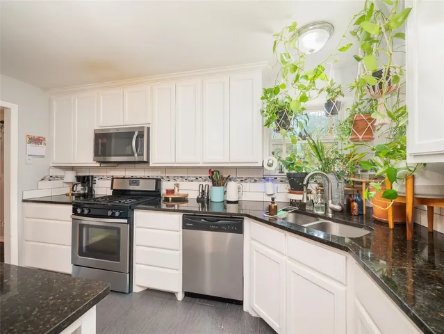 a kitchen with granite countertop white cabinets and white appliances
