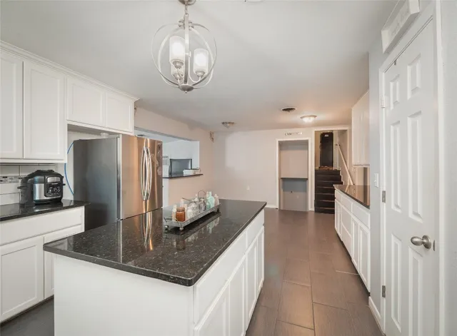 a kitchen with stainless steel appliances granite countertop a sink refrigerator and cabinets
